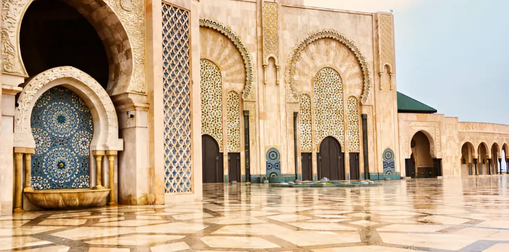 "Close-up view of the ornate exterior of Hassan II Mosque in Casablanca, showcasing intricate Moroccan tilework and arches."